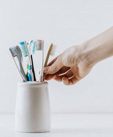 Hand reaches for brush in holder