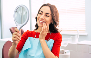 Woman smiling in dental chair after seeing dentist in Bullard