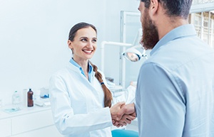 Woman shaking hand with man in dental office