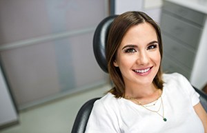 Woman smiling while sitting in the dental chair