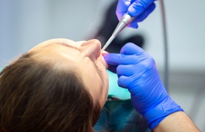 A patient sedated while a dentist performs a tooth extraction