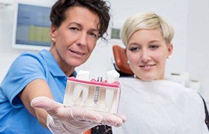 Dentist showing patient implant model