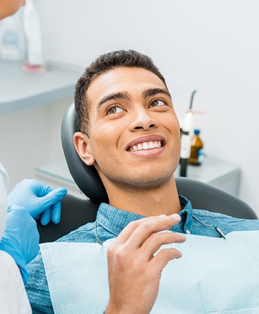 Patient smiling at dentist with pink mirror