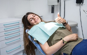 Female dental patient giving thumbs up