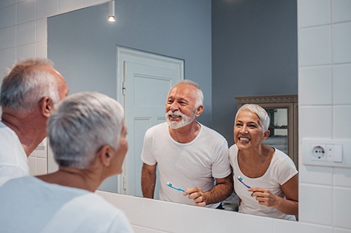 seniors brushing teeth laughing