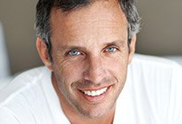 Older man in white shirt smiling