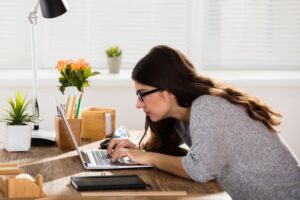 a woman slouching over her laptop