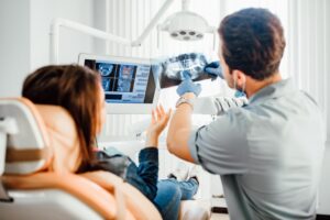 Dentist holding up X-ray for patient to see. 