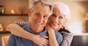 Older couple with dental implants smiling
