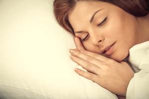A woman with sleep apnea sleeping in a bed.