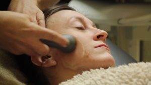 A woman undergoing TruDenta headache therapy at a spa.